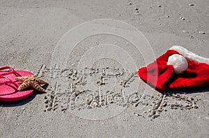 Tropical Christmas at the beach, with happy holidays written in