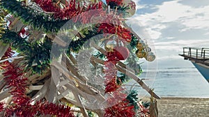 Tropical Christmas tree with star and red baubles at ocean shore in exotic country. Tropical paradise at Xmas.