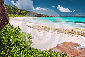 Tropical coast at La Digue island, Seychelles. Lush green vegetation, turquoise blue ocean on long beautiful sandy beach