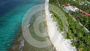 Tropical coastline with ocean, sandy beach and road in Fuvahmulah island. Aerial view