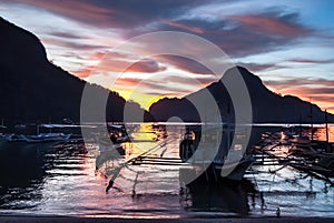 Tropical colorful sunset with a banca boats in El Nido, Palawan