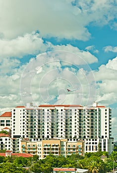 Tropical condominiums and a passenger jet airplane, climbing