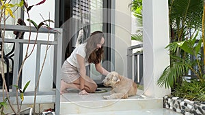 Tropical country beautiful hotel white walls porch European girl on vacation with her beloved pet girl on the porch