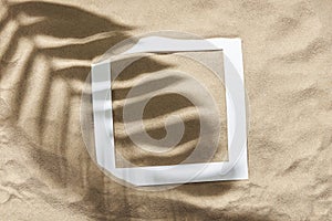 Tropical design, sand background, leaf shadow and paper frame: summer, vacations