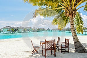 Tropical dining place under the palm tree at the beach