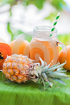 Tropical exotic pineapple and papaya fruits with jar smoothie sh
