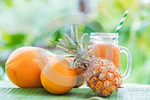 Tropical exotic pineapple and papaya fruits with jar smoothie sh