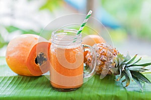 Tropical exotic pineapple and papaya fruits with jar smoothie sh