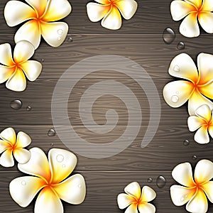 Tropical flowers and water drops on a wooden background