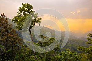 Tropical forest with mountains and majestic orange sky and clouds. Camping site at Maewong National Park, Nakhonsawan, Thailand