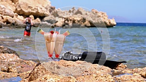 Tropical Fresh Juice in a Glass with Straw on the Beach of Egypt Stands on a Rock by the Sea. Slow Motion