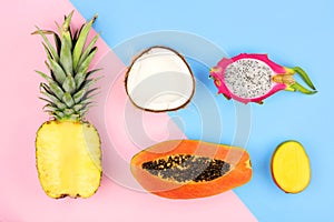 Tropical fruit flat lay on a pastel pink and blue background