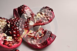 Tropical fruit - juicy, ripe red pomegranate on a white background