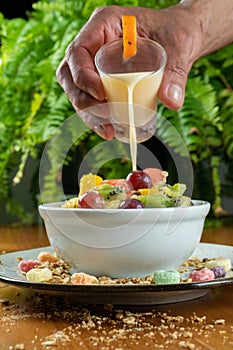 Pouring yogurt on fruit salad photo