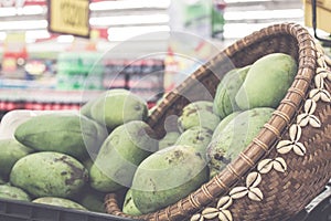 Tropical fruits close up green mangoes in the asian shop. Bali island, Indonesia. Organic market.