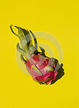 Tropical fruits: dragon fruit, pitahaya on a yellow background, top view, copy space