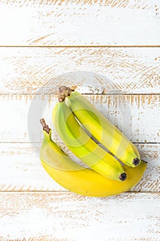 Tropical Fruits Ripe Yellow and Green Bananas on White Planked Wood Background. Healthy Diet Vitamins