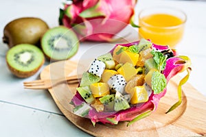 Tropical fruits salad served in a half of  dragon fruit