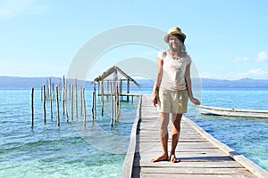 Tropical girl on jetty with shelter on sea