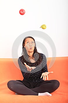 Tropical girl juggling with apple and pear
