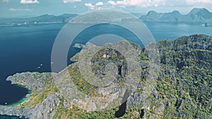 Tropical green forest on mountain ranges at ocean bay aerial view. Landscape of mountainous island