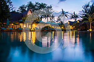 Tropical hotel with swimming pool at night with reflections and palms, Gili Trawangan, Lombok, Indonesia