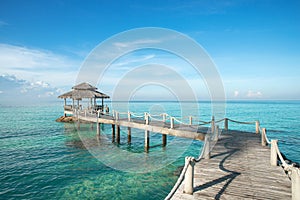 Tropical hut and wooden bridge at holiday resort - summer vacation background