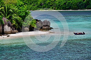 Tropical island with boat, Therese Island, Mahe, Seychelles. Horizontal view.