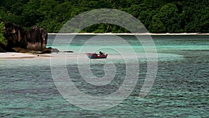 Tropical island with boat, Therese Island, Mahe, Seychelles. Horizontal view.
