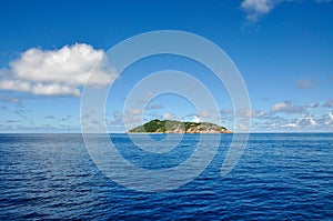 Tropical island coastline in the ocean with blue sky photo