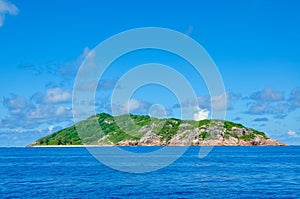 Tropical island coastline in the ocean with blue sky photo