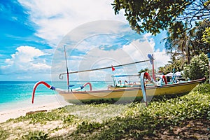 Tropical island in Indonesia, blue ocean and traditional boats on a sandy beach