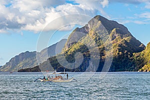 Tropical island landscape with bangca traditional philippines boat full of tourist, El Nido, Palawan