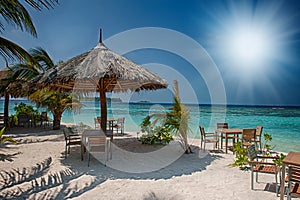 Tropical island with palm trees and amazing vibrant beach in Maldives. White parasol in sea tropical Maldives romantic atoll