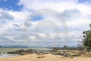 Tropical island - sand and stones on the shore and a religious Buddhist building on the pier. Koh Phayam Island, Thailand