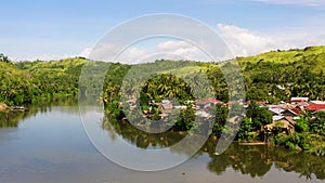 Tropical landscape in sunny weather. Village by the river. The nature of the Philippines, Samar