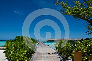 Tropical landscape with wooden bridge and water bungalos at Maldives