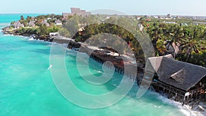 Tropical Landscape of Zanzibar, Waves Hit Reef on Hotels Coastline with Palms