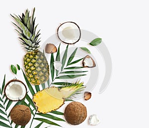 Tropical layout with fresh exotic fruits and green leaves on white background
