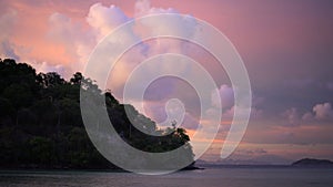 Tropical ocean view with close-up island in pink sunset twilight sky