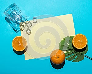 Tropical palm leaf with sliced orange on bright blue background. Minimal summer composition. Flat lay