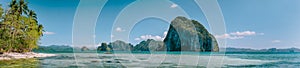 Tropical panorama scenery of coastline with huge rocky island on the background. National Marine Park El Nido, Palawan