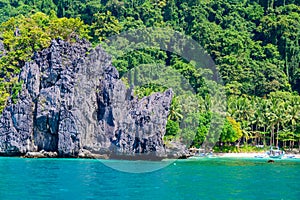 Tropical Papaya beach at paradise coast, El Nido, Palawan, Philippines. Tour A Route. Coral reef and sharp limestone cliffs