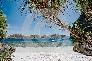 Tropical paradise beach on Entalula Island. Blue lagoon surrounds by karst limestone rocky mountains