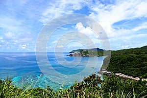 Tropical paradise of a pristine white beach, greenery, turquoise sea and deep blue sunny sky at Zamami, Okinawa, Japan