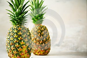 Tropical pineapples on gray background. Summer, holiday concept. Raw, vegan, vegetarian, clean eating diet. Close up of