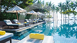 tropical pool with palm trees and beach bed chairs, beach chairs with beach towel at a pool