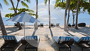 tropical pool with palm trees and beach bed chairs, beach chairs with beach towel at a pool