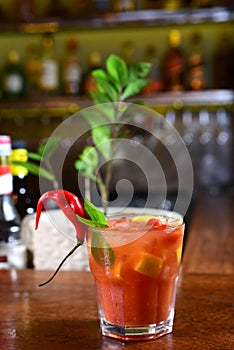 Tropical red fruit drink served in an exotic glass with dehydrated fruits and ice