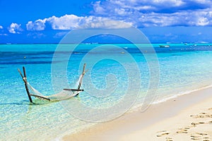 Tropical relaxing holidays - hammock in turquoise water in Maldive islands.